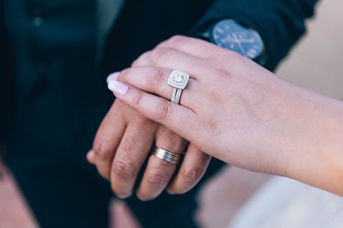 a couple showing the engagement rings